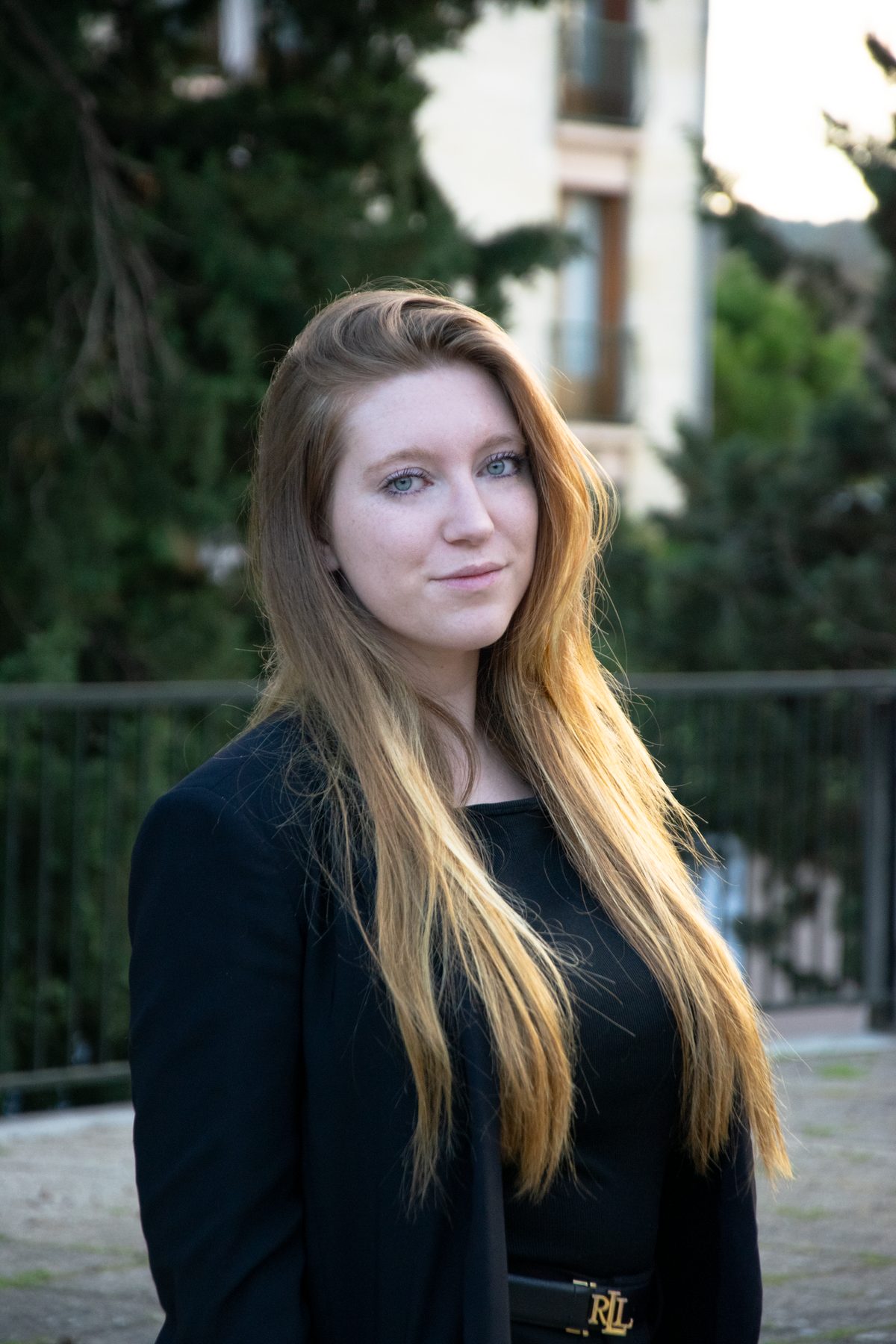 Portrait urbain d’Agathe devant une grille en fer forgé